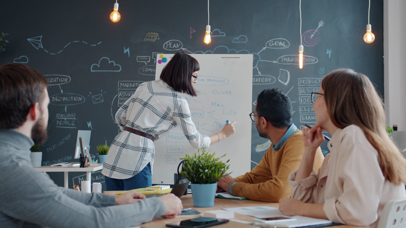 A team discussing ideas around a whiteboard in a bright office